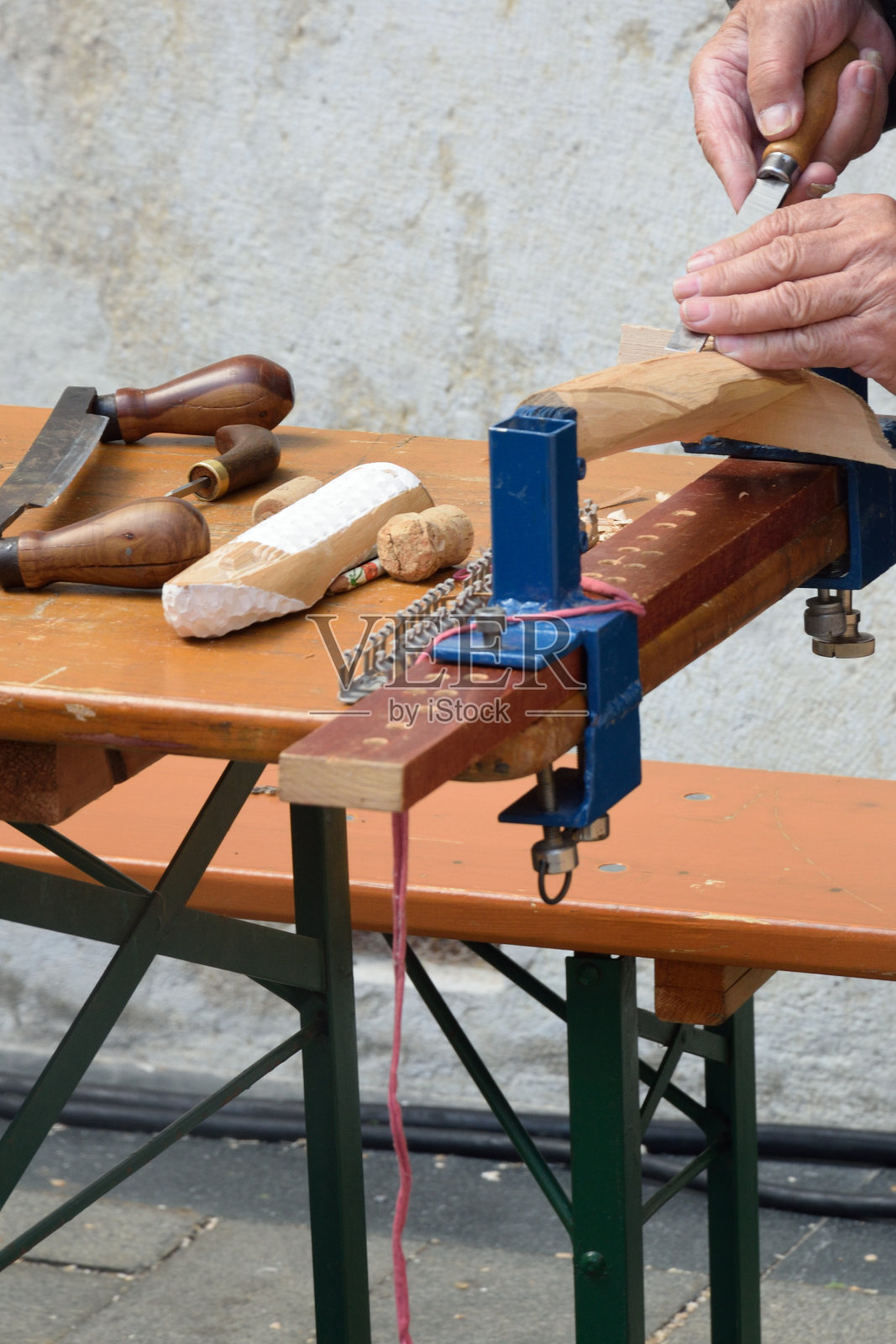 人在长凳上雕刻木头照片摄影图片