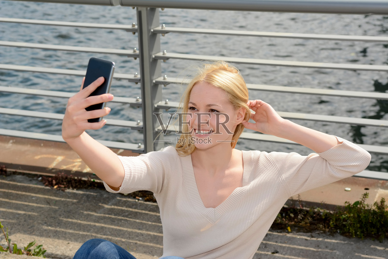 年轻女子用智能手机自拍照片摄影图片