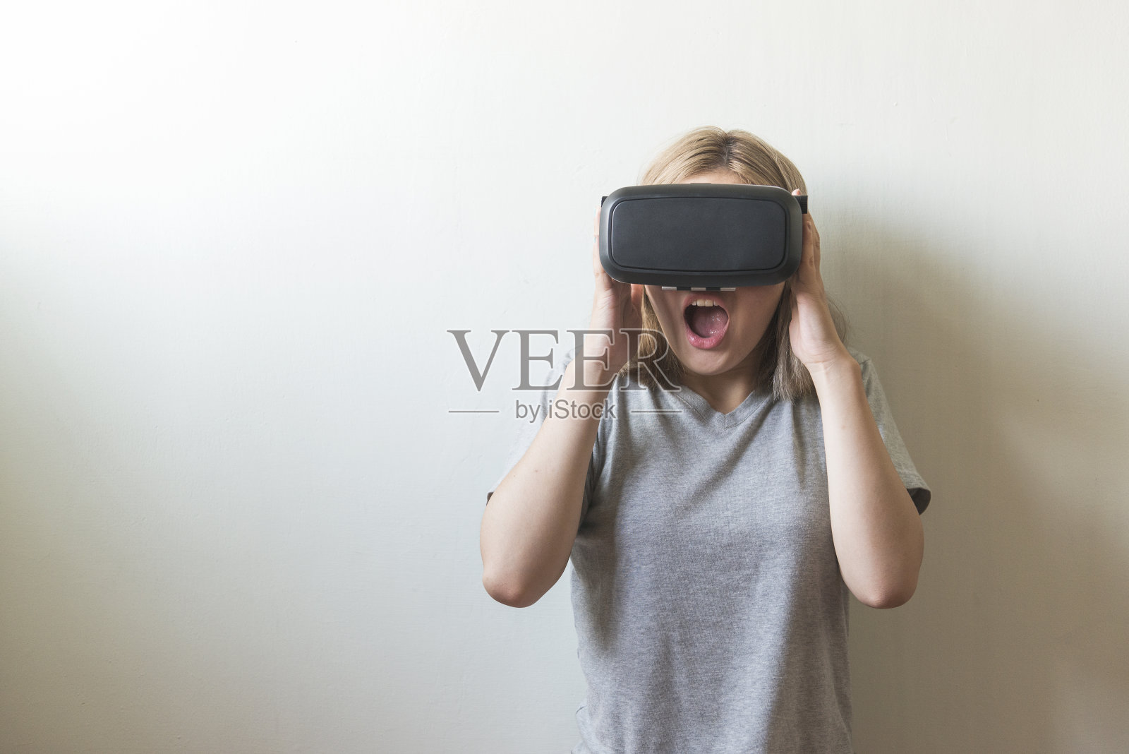 在白色背景上使用虚拟现实耳机的女人照片摄影图片