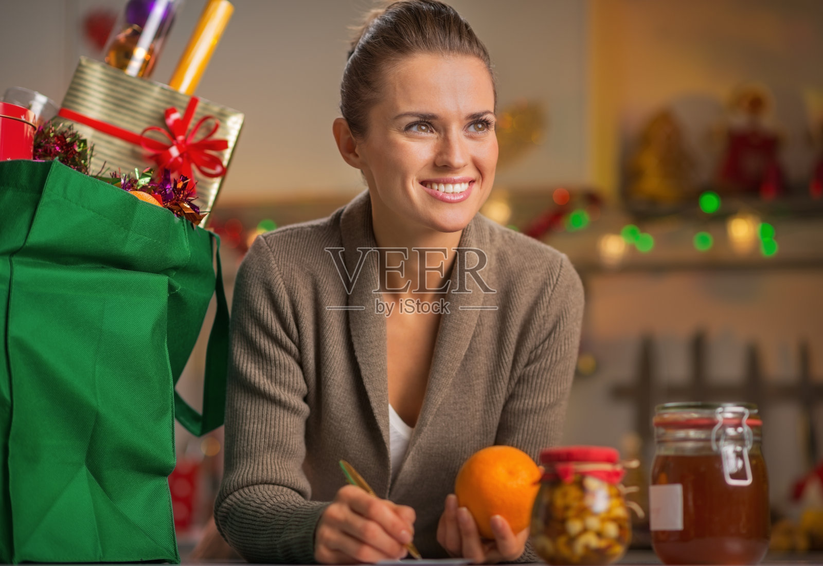 快乐的家庭主妇，厨房里有圣诞购物袋照片摄影图片