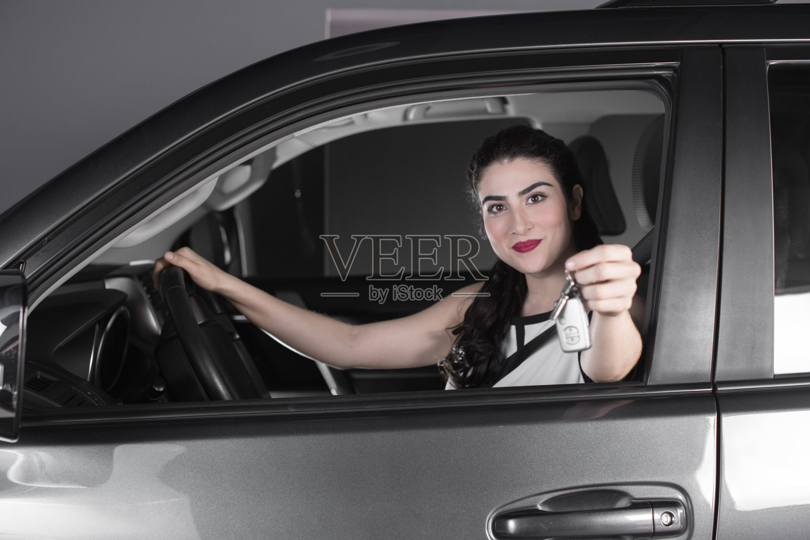 坐在车里的女人拿着钥匙照片摄影图片