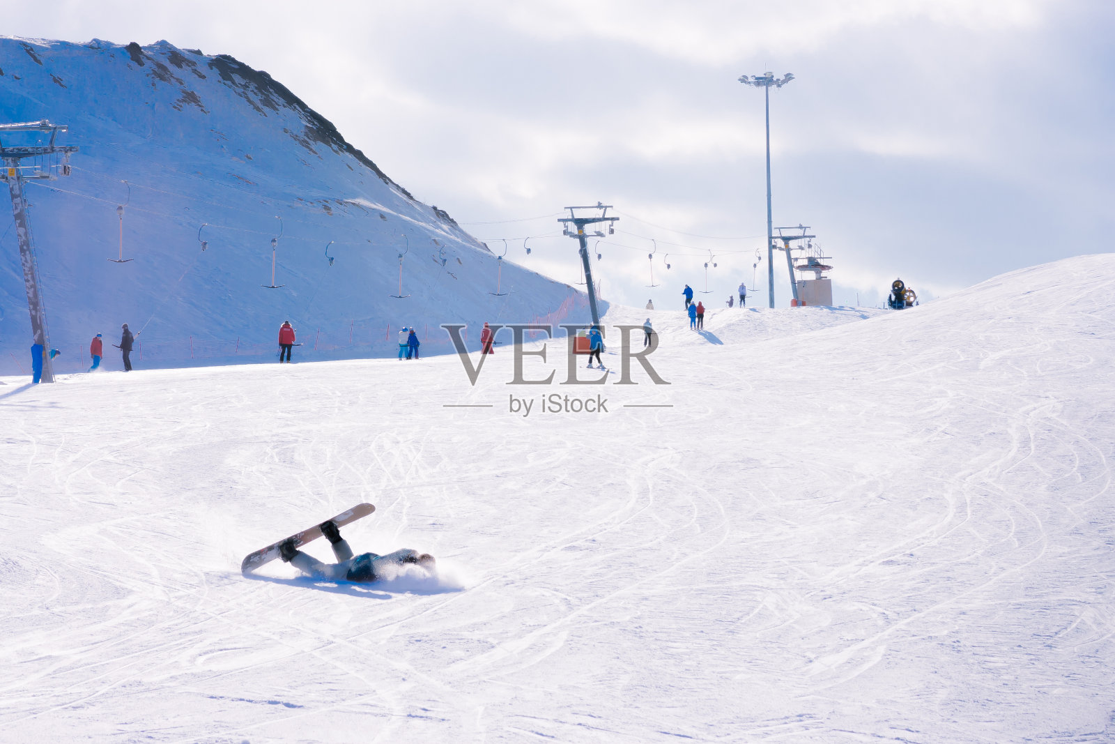 滑雪者在滑雪斜坡上摔倒了。照片摄影图片