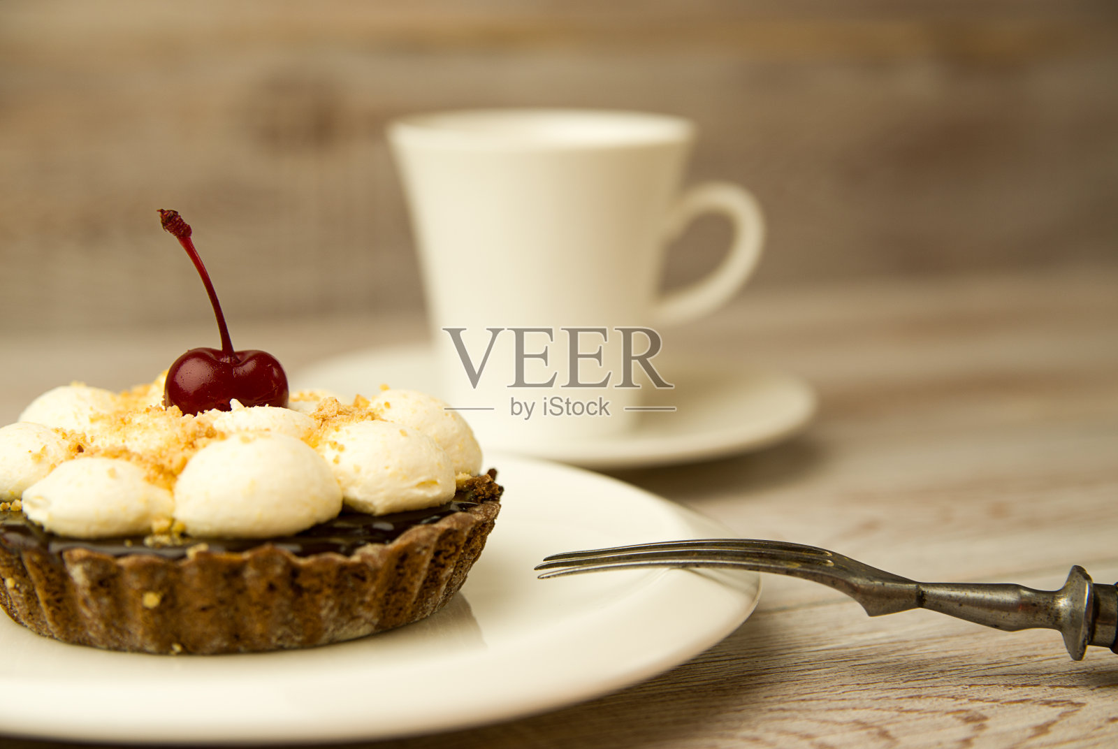 桌上有樱桃蛋糕和杯子照片摄影图片