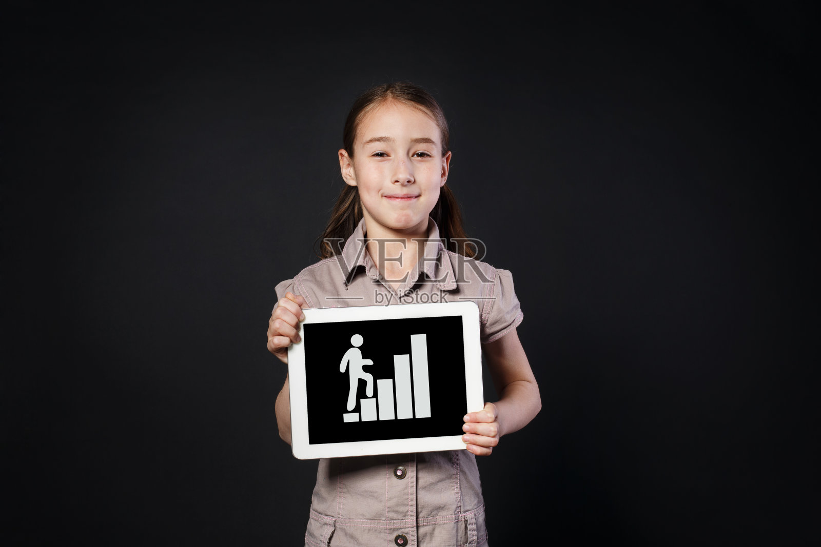 小女孩展示数字平板电脑屏幕和楼梯图照片摄影图片