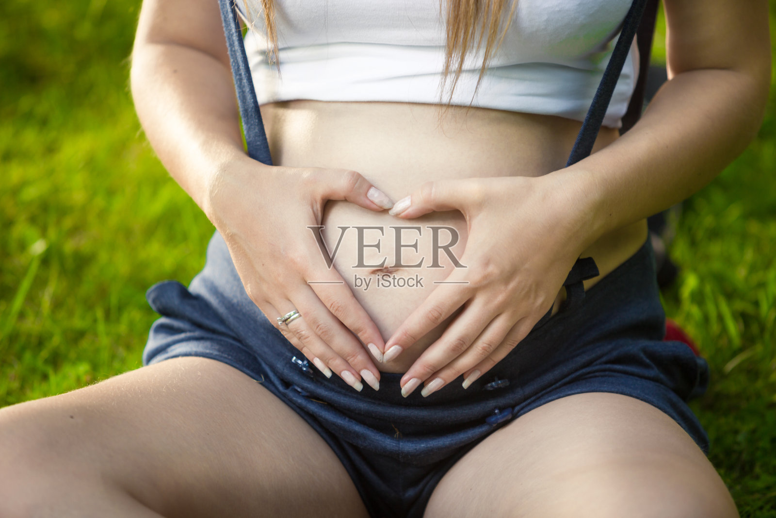 关怀孕妇的手在腹部心形照片摄影图片