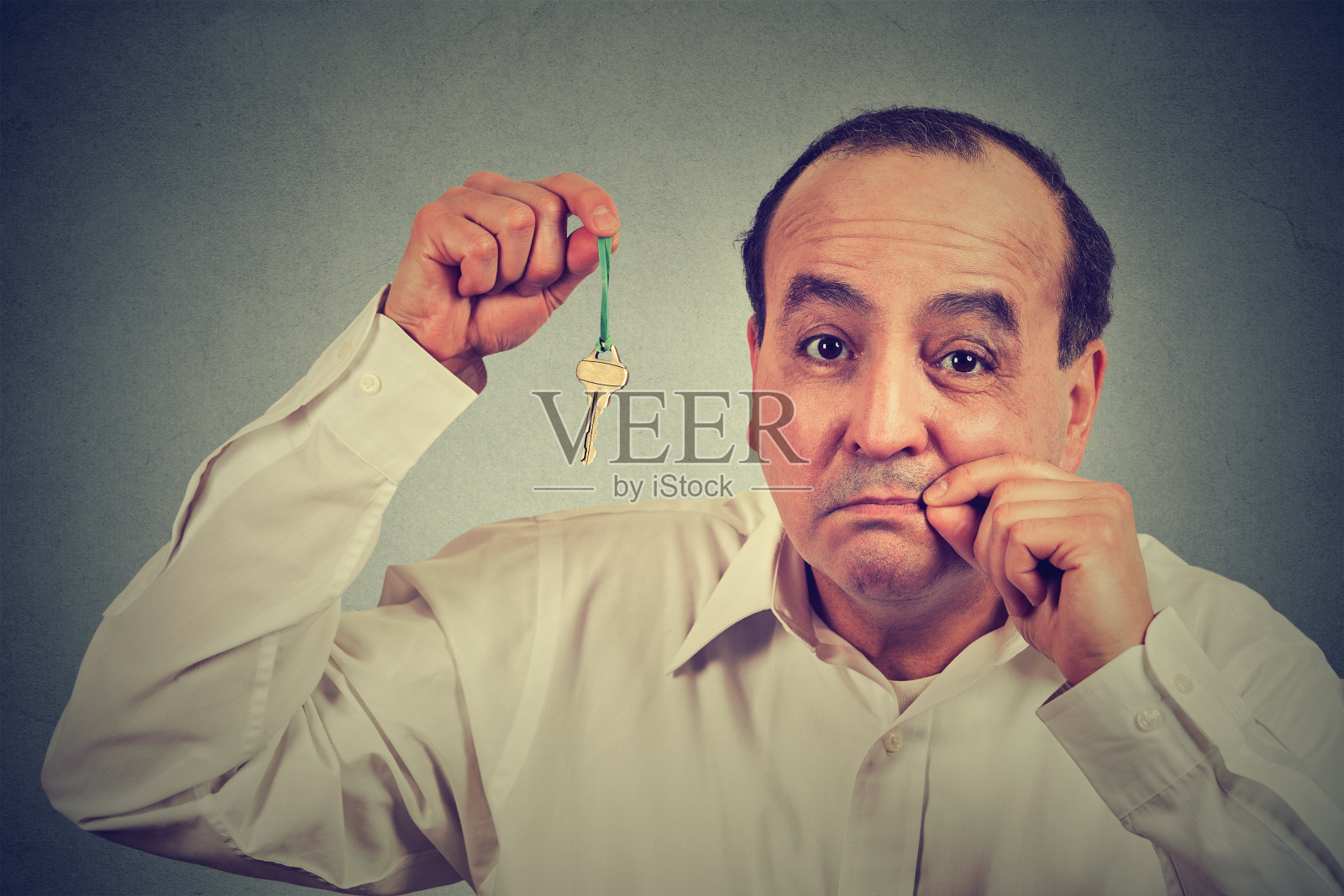 一个闭着嘴拿着钥匙的人照片摄影图片