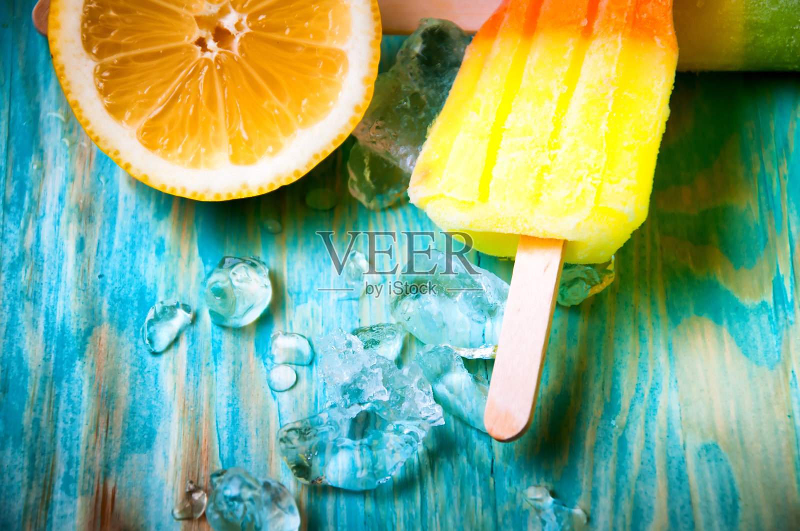 五颜六色的冰棍和水果在蓝色的木制背景照片摄影图片