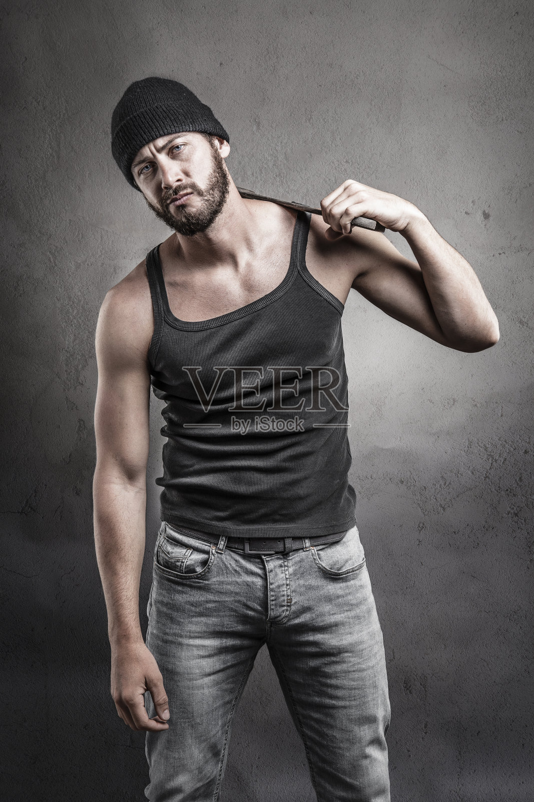 困惑的男人拿着扳手站在那里照片摄影图片