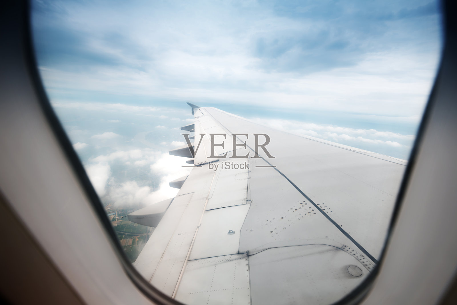透过飞机窗户看到的云朵和天空照片摄影图片
