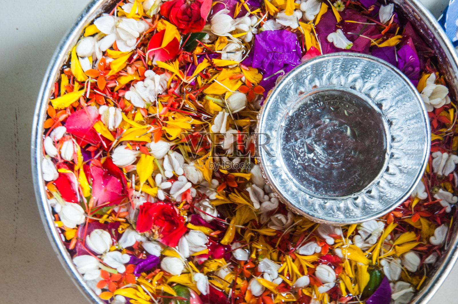 水在水斗里，带着五颜六色的花照片摄影图片