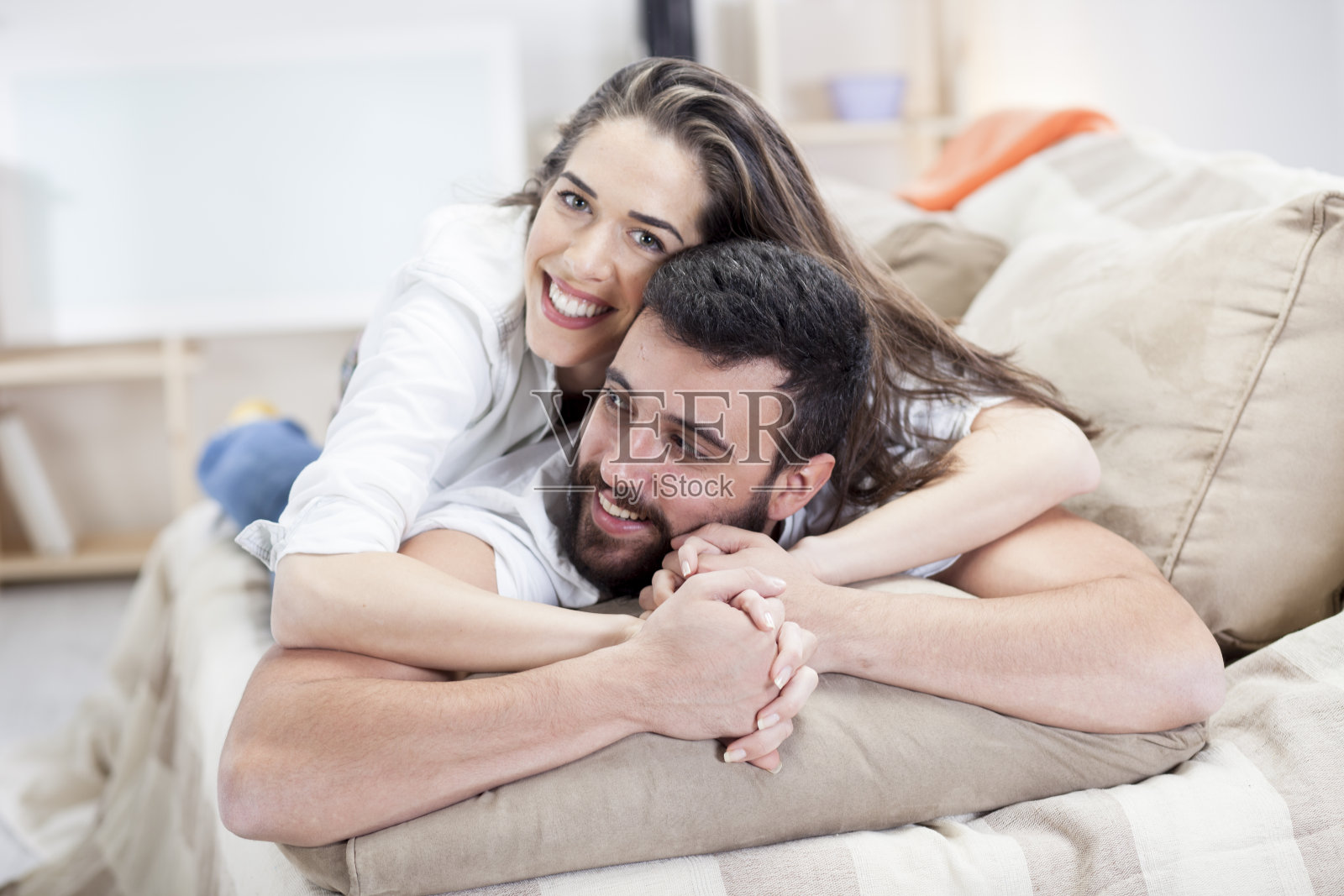 一对幸福的夫妇躺在客厅的沙发上照片摄影图片