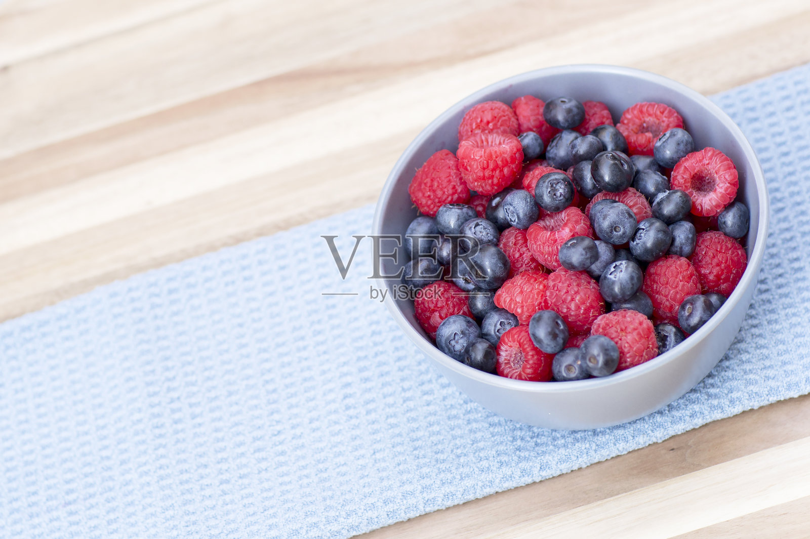 甜点新鲜的浆果在碗里。照片摄影图片