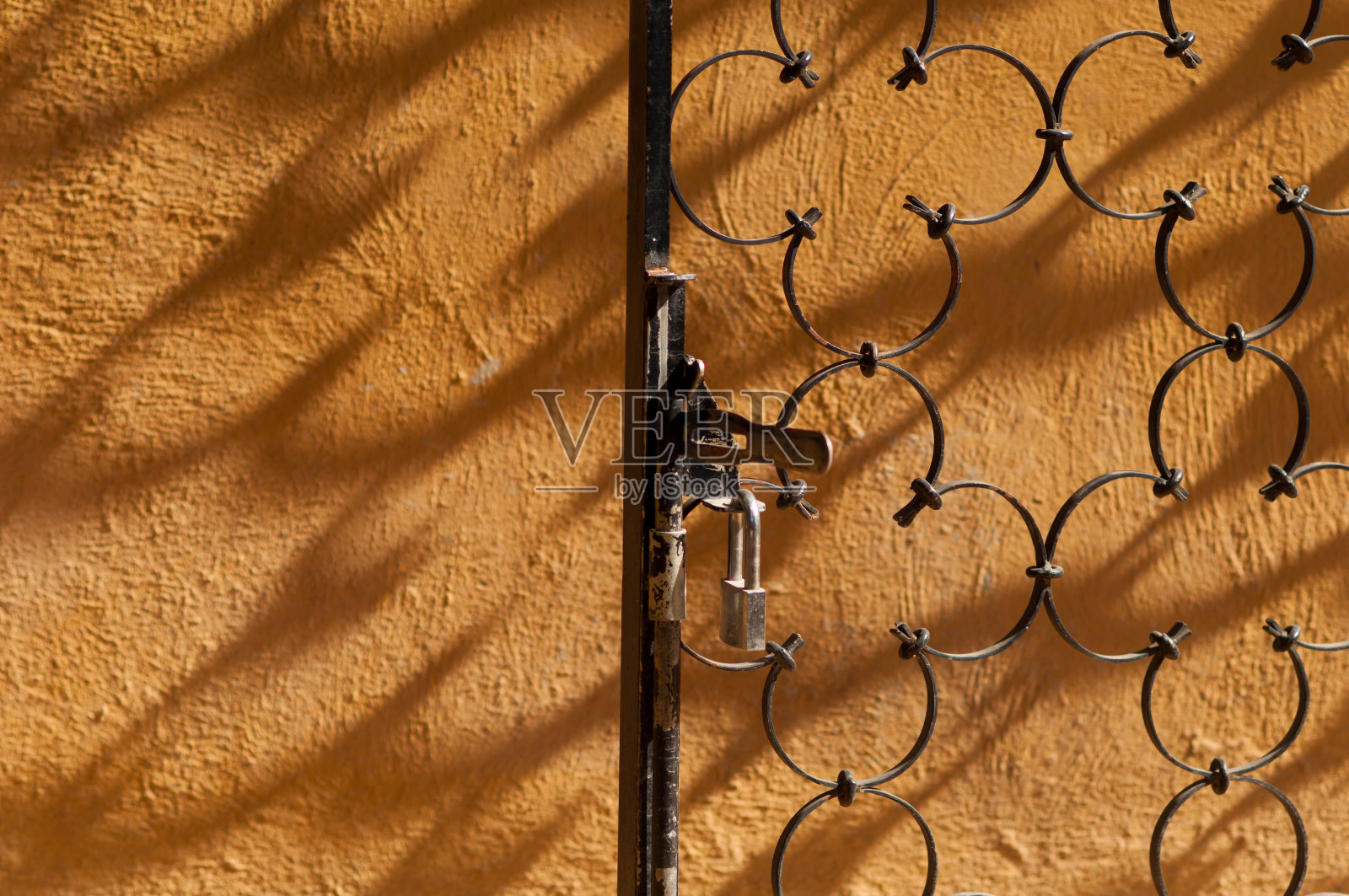 旧金属栅栏装饰门锁上的黄色背景照片摄影图片