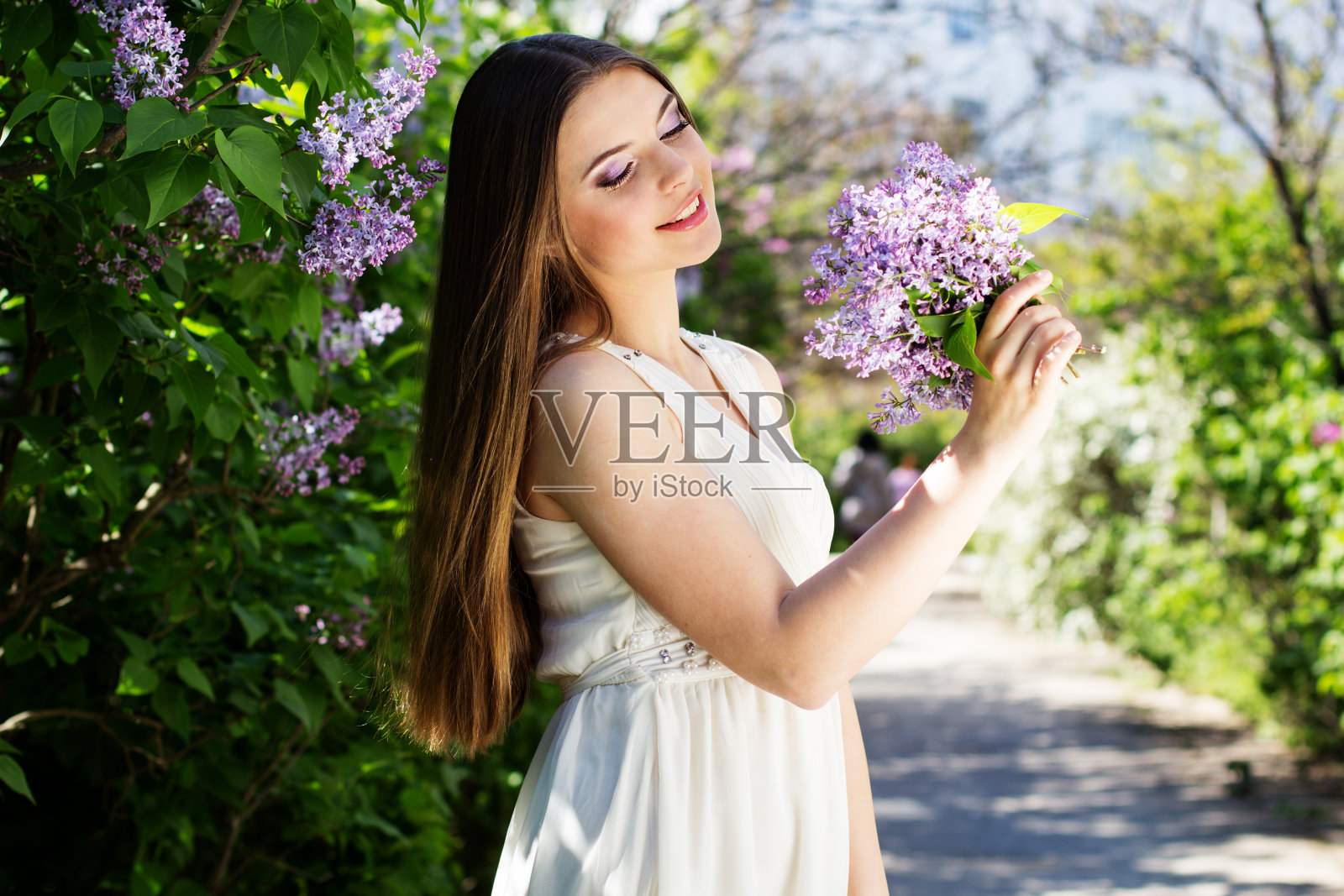 带着丁香花的漂亮女孩照片摄影图片