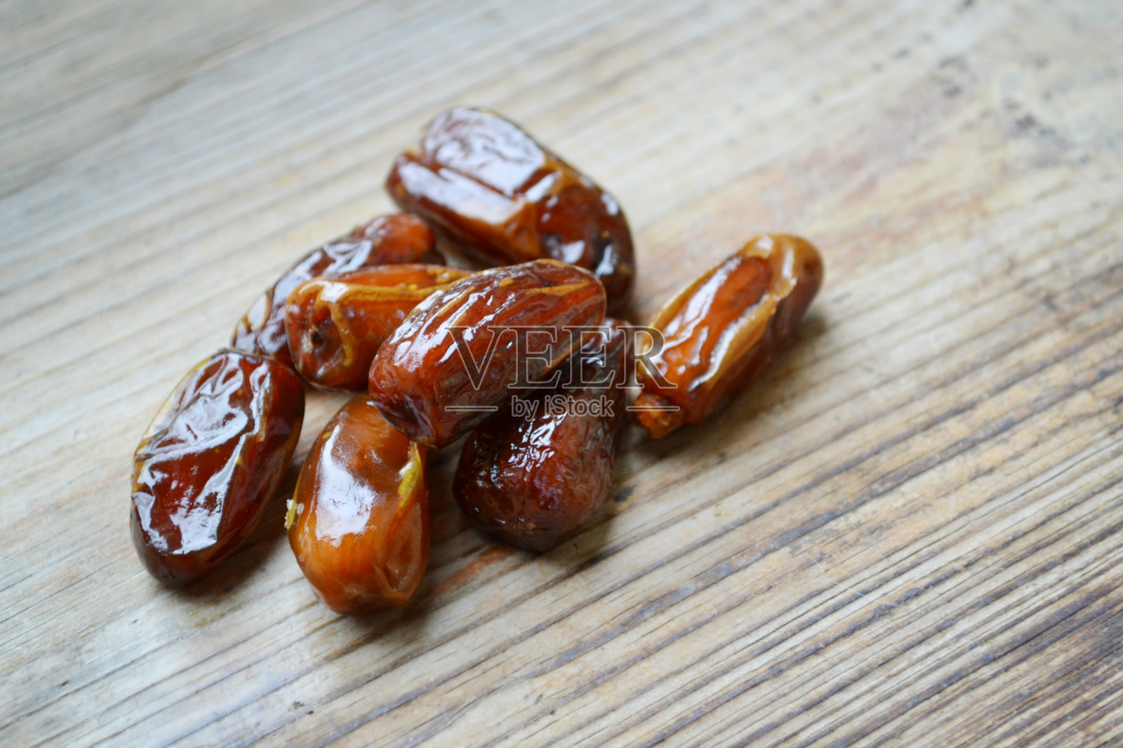 木桌上的棕色枣椰果照片摄影图片