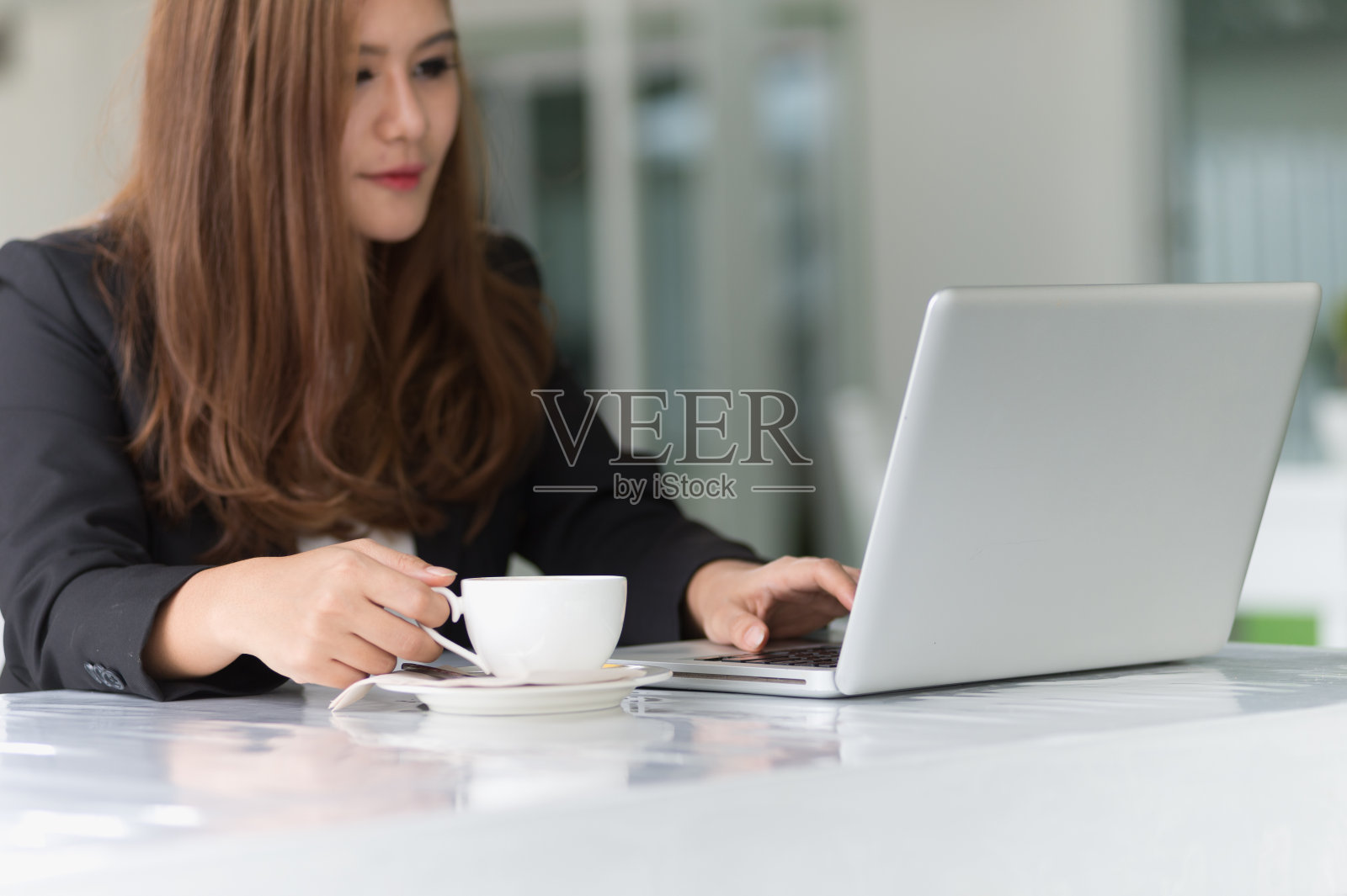 亚洲年轻的商业女性在咖啡馆与笔记本电脑和咖啡照片摄影图片