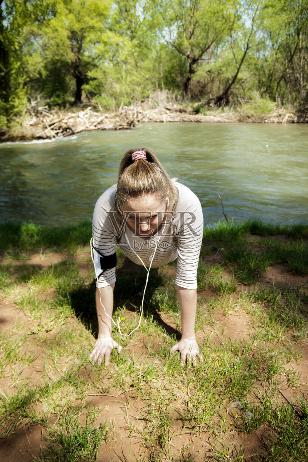 美丽的女孩在河边做运动。照片摄影图片
