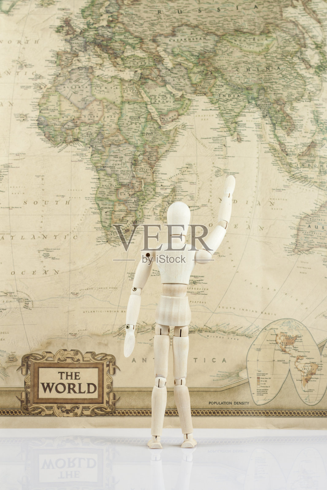 木制娃娃与手向上看在世界地图上照片摄影图片