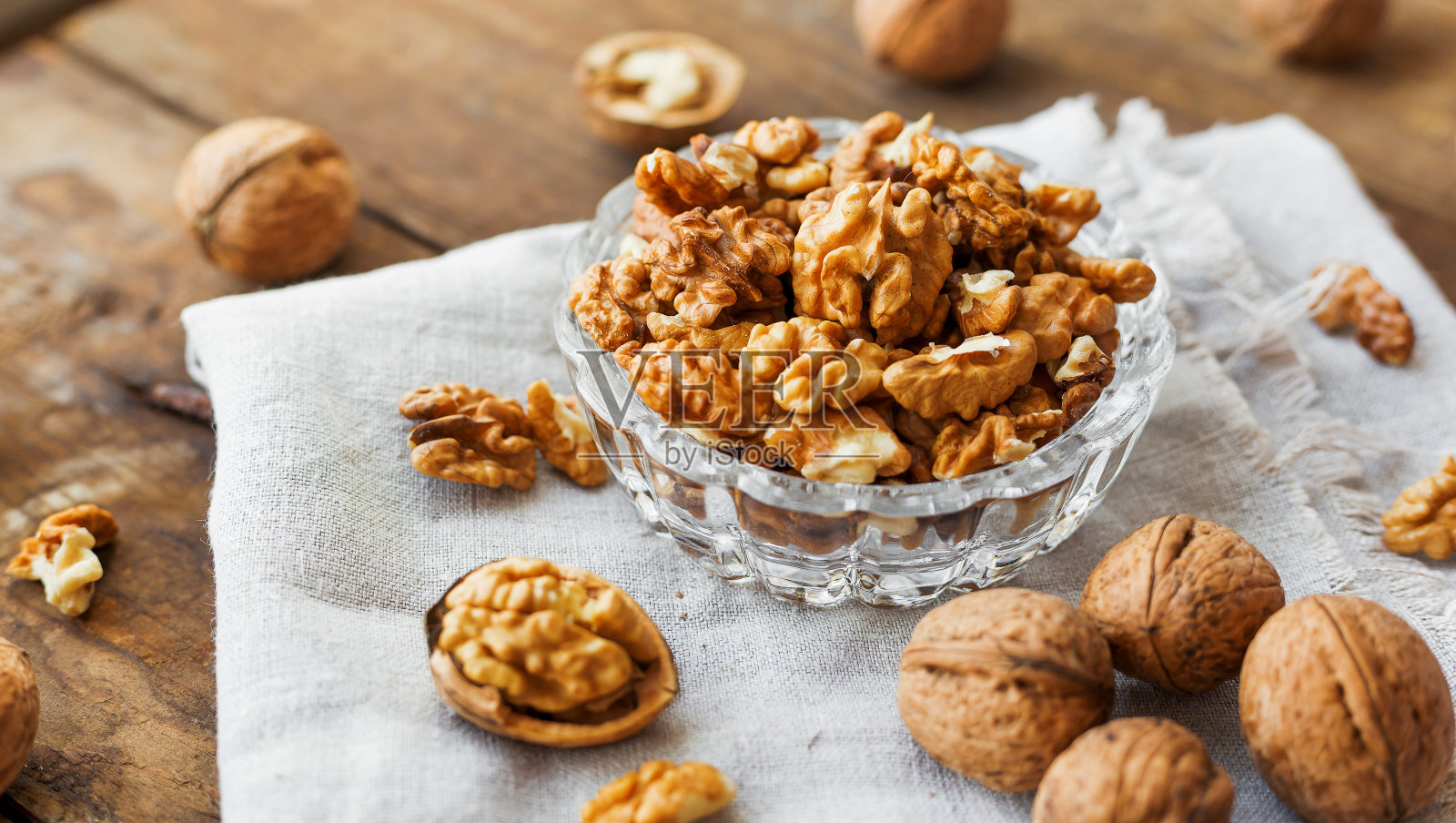 玻璃碗，核桃，土布餐巾。健康的零食。照片摄影图片