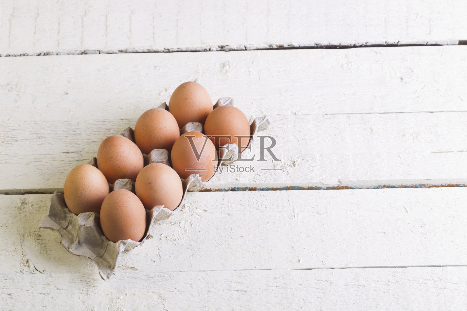 鸡蛋放在白板上的纸板盘里。照片摄影图片