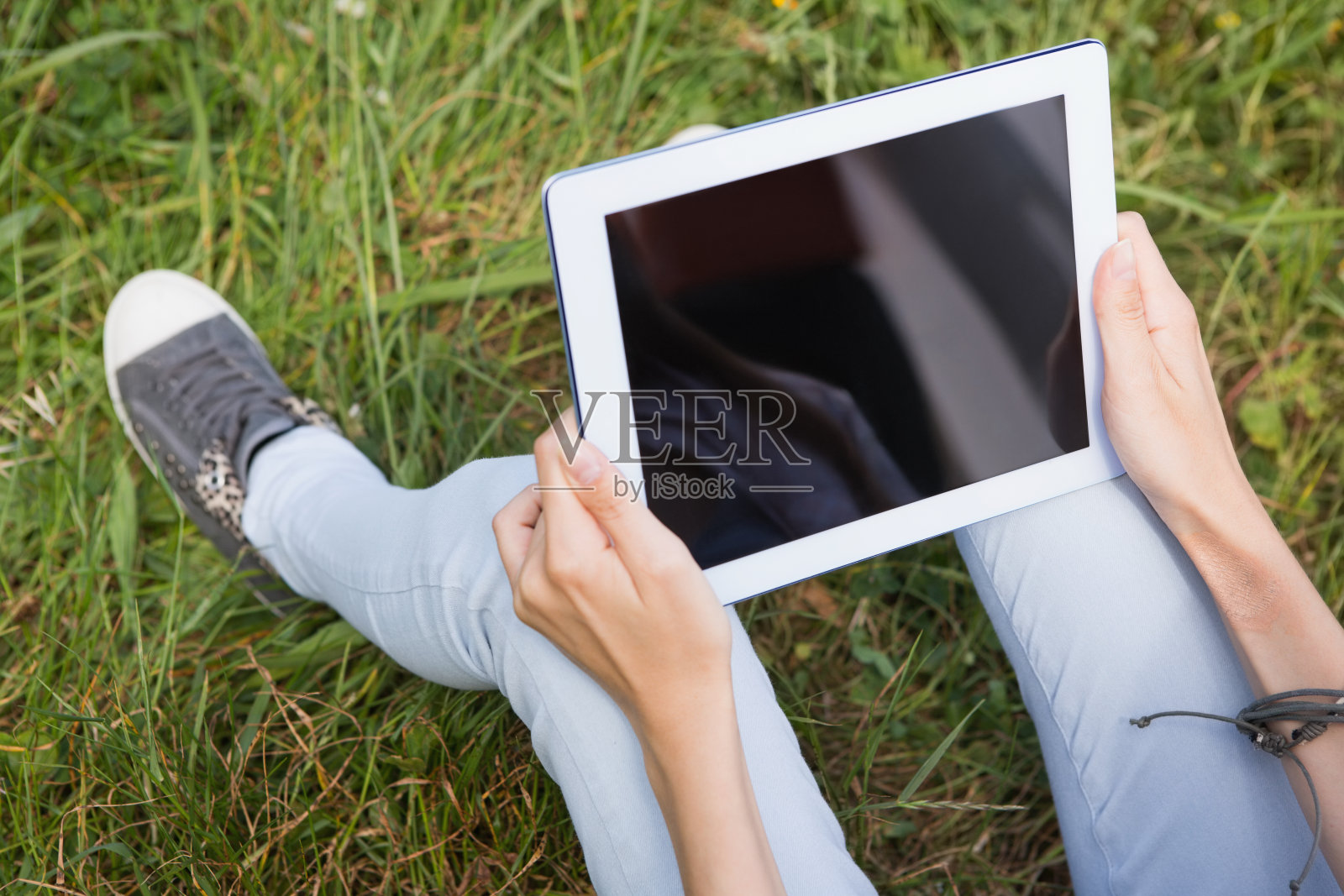 在公园里用平板电脑的女人照片摄影图片