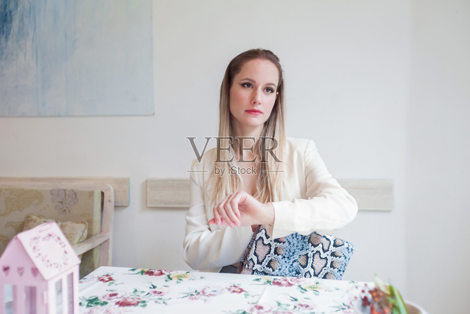 迷人的年轻女子在餐厅看手表。照片摄影图片