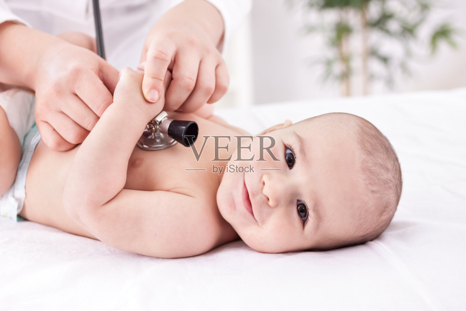 微笑美丽快乐的宝宝与儿科医生照片摄影图片