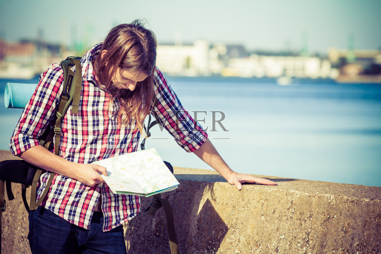 背着背包在海边徒步旅行的男子照片摄影图片