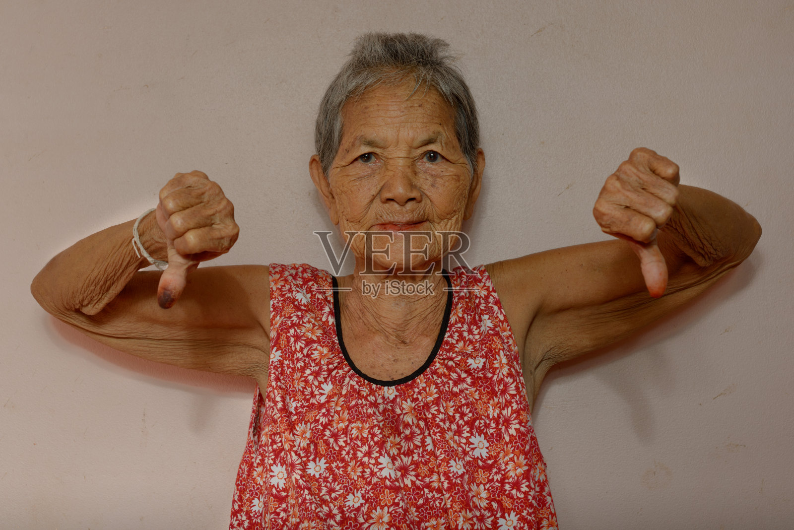 年老的亚洲妇女给予拇指向下照片摄影图片