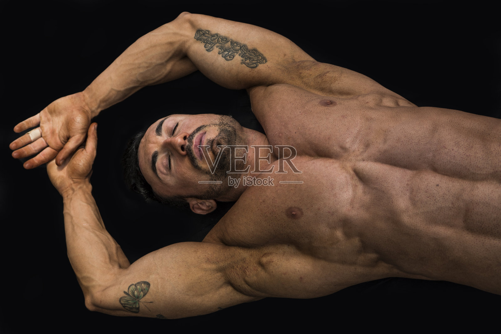 英俊的年轻肌肉男躺在地板上照片摄影图片