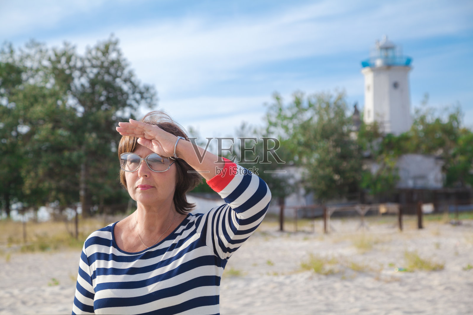 在海边遥望远方的老妇人照片摄影图片