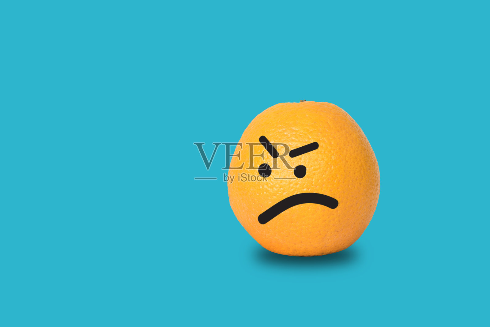 橙色的脸在蓝色的背景上生气。照片摄影图片