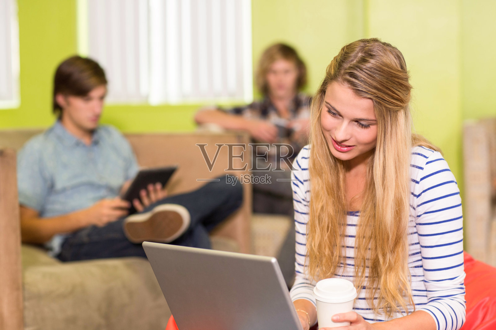 在办公室使用笔记本电脑的年轻女子照片摄影图片