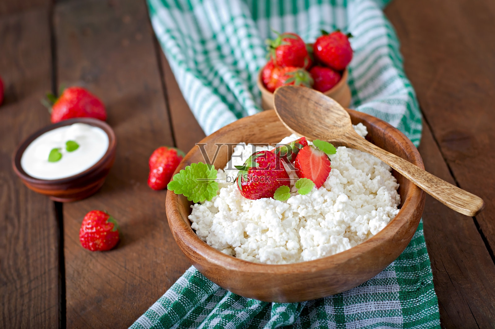 用木碗盛着草莓和白干酪照片摄影图片