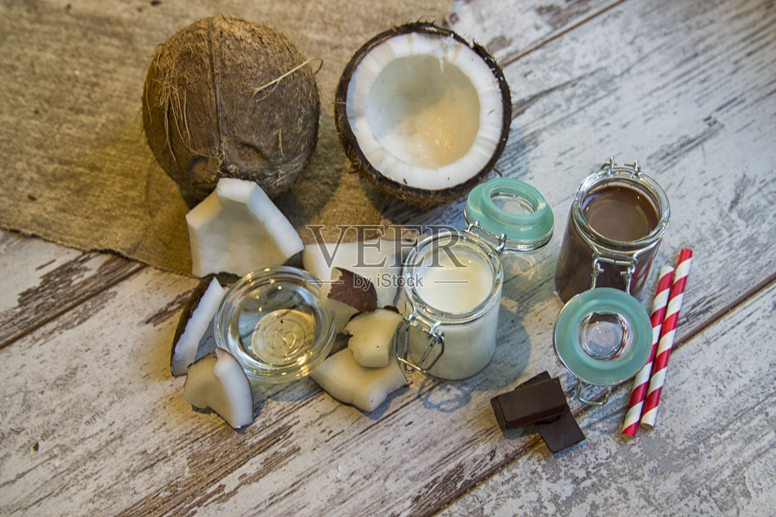 巧克力牛奶蛋白奶昔配彩色条纹吸管和椰子照片摄影图片