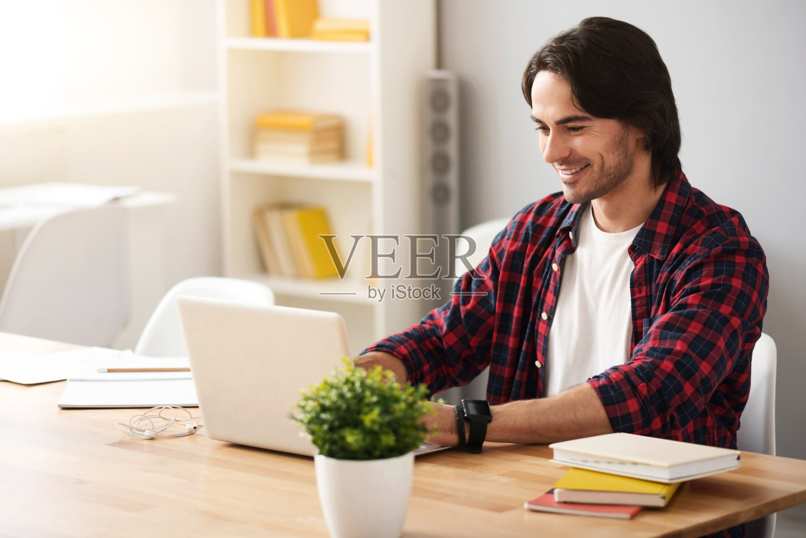 一个愉快的微笑的人坐在桌子旁照片摄影图片