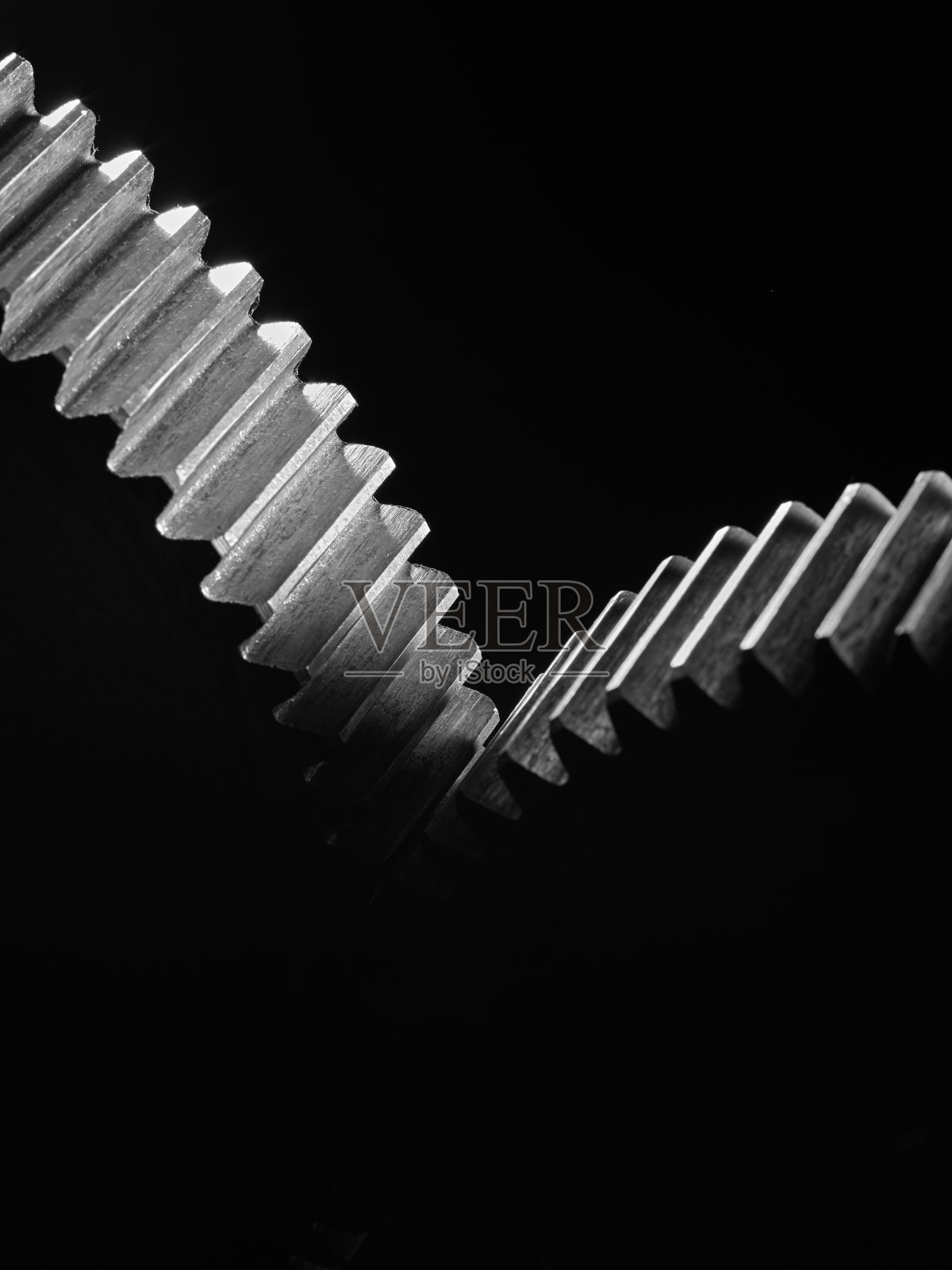 黑色背景上的两个金属齿轮。照片摄影图片