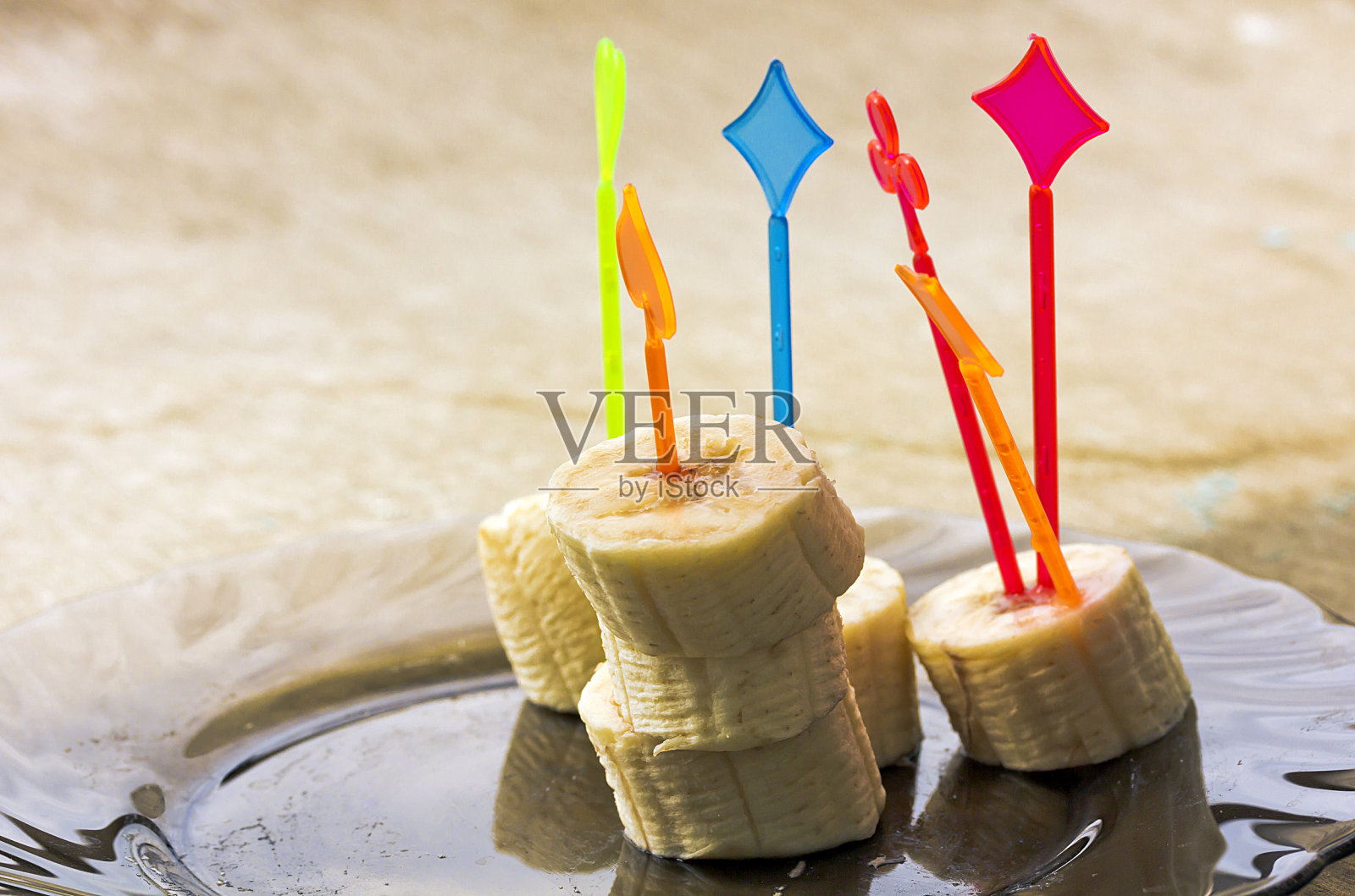 把香蕉片串起来放在木桌上照片摄影图片