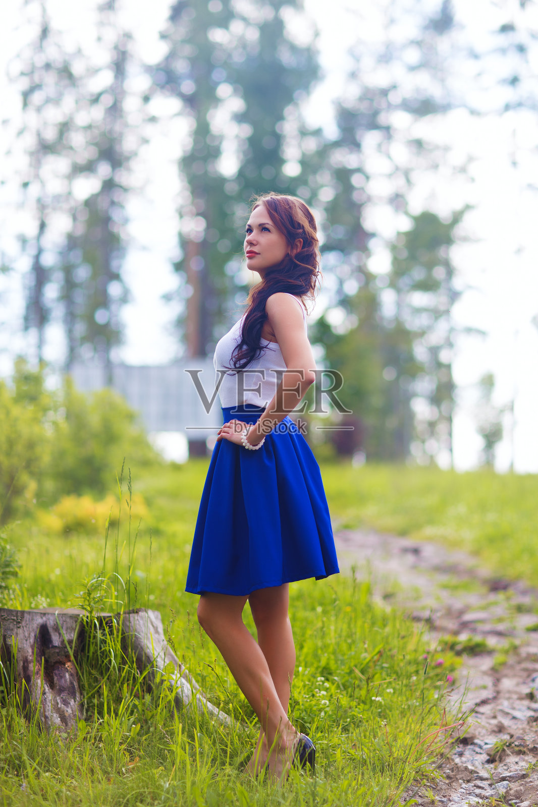 年轻漂亮的女人摆出在日落室外展示连衣裙照片摄影图片