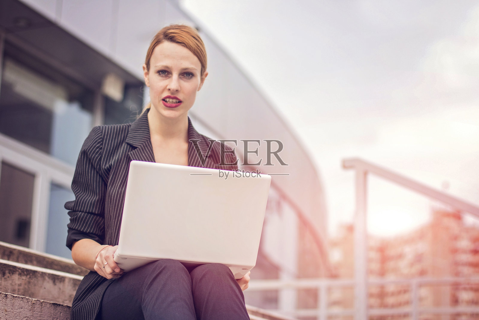 商务女性在户外使用笔记本电脑照片摄影图片