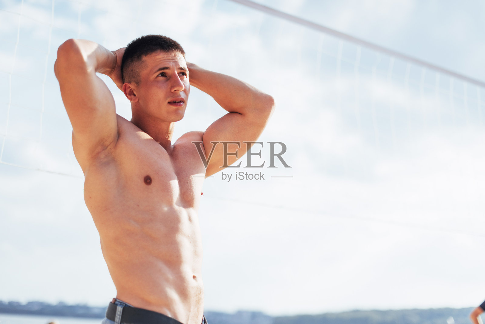 肌肉男模特与完美的身体姿势在蓝色牛仔裤照片摄影图片