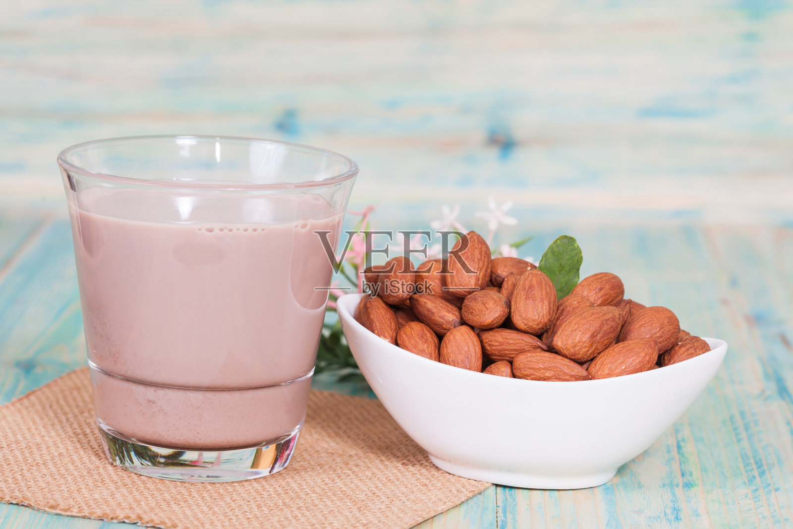 木色背景的碗里杏仁和巧克力牛奶照片摄影图片