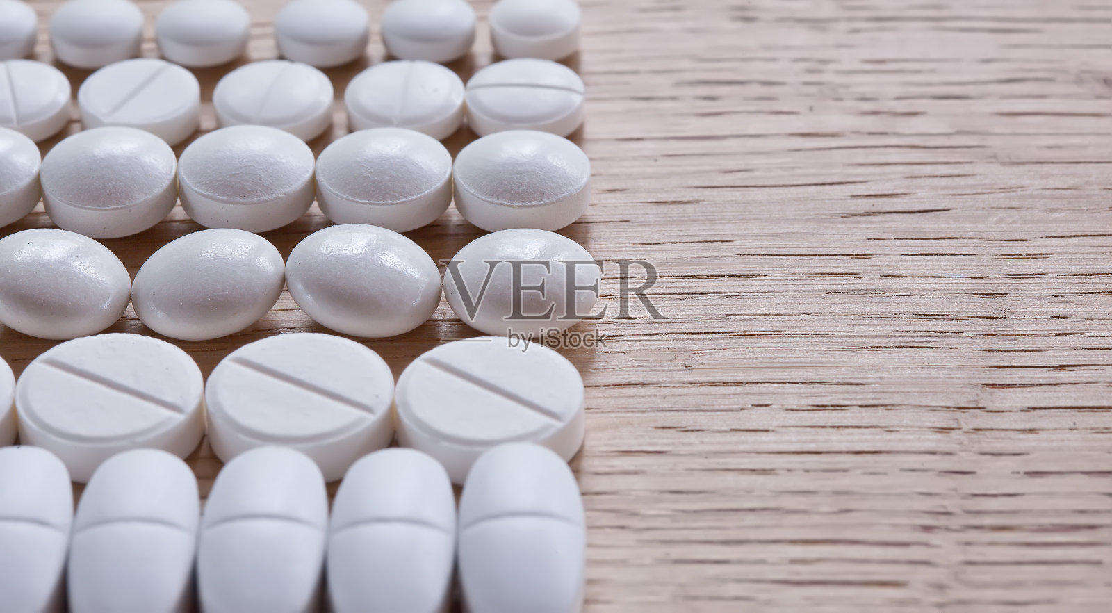 木质表面有白色药丸照片摄影图片