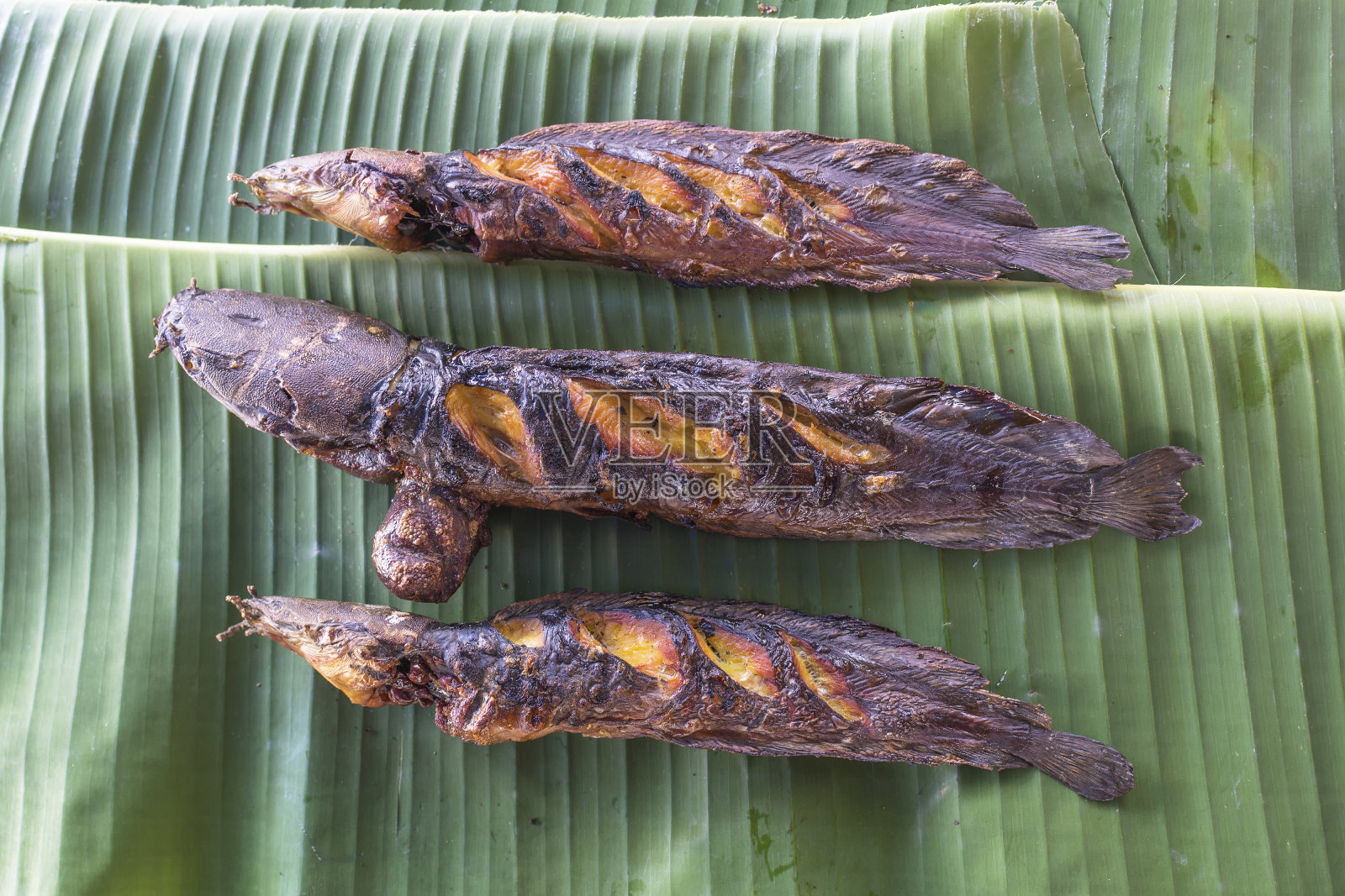 烤鲶鱼芭蕉叶背景照片摄影图片