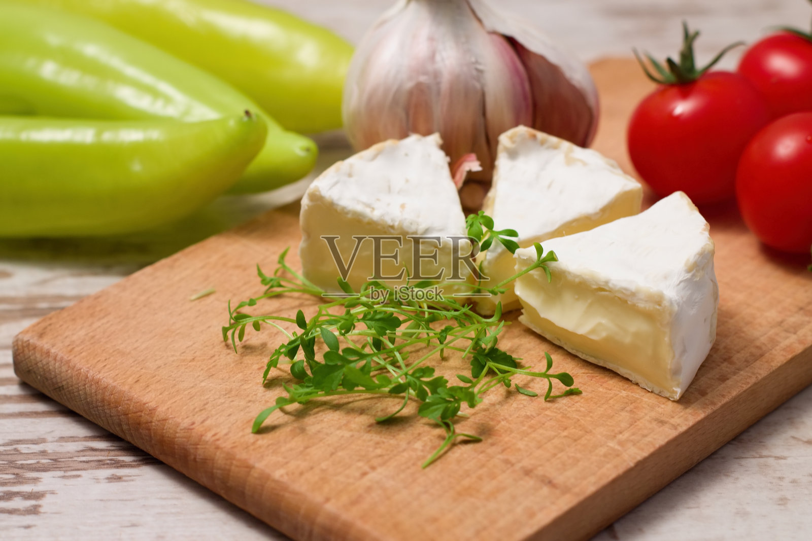 三份卡门贝尔干酪和水芹放在木板上照片摄影图片