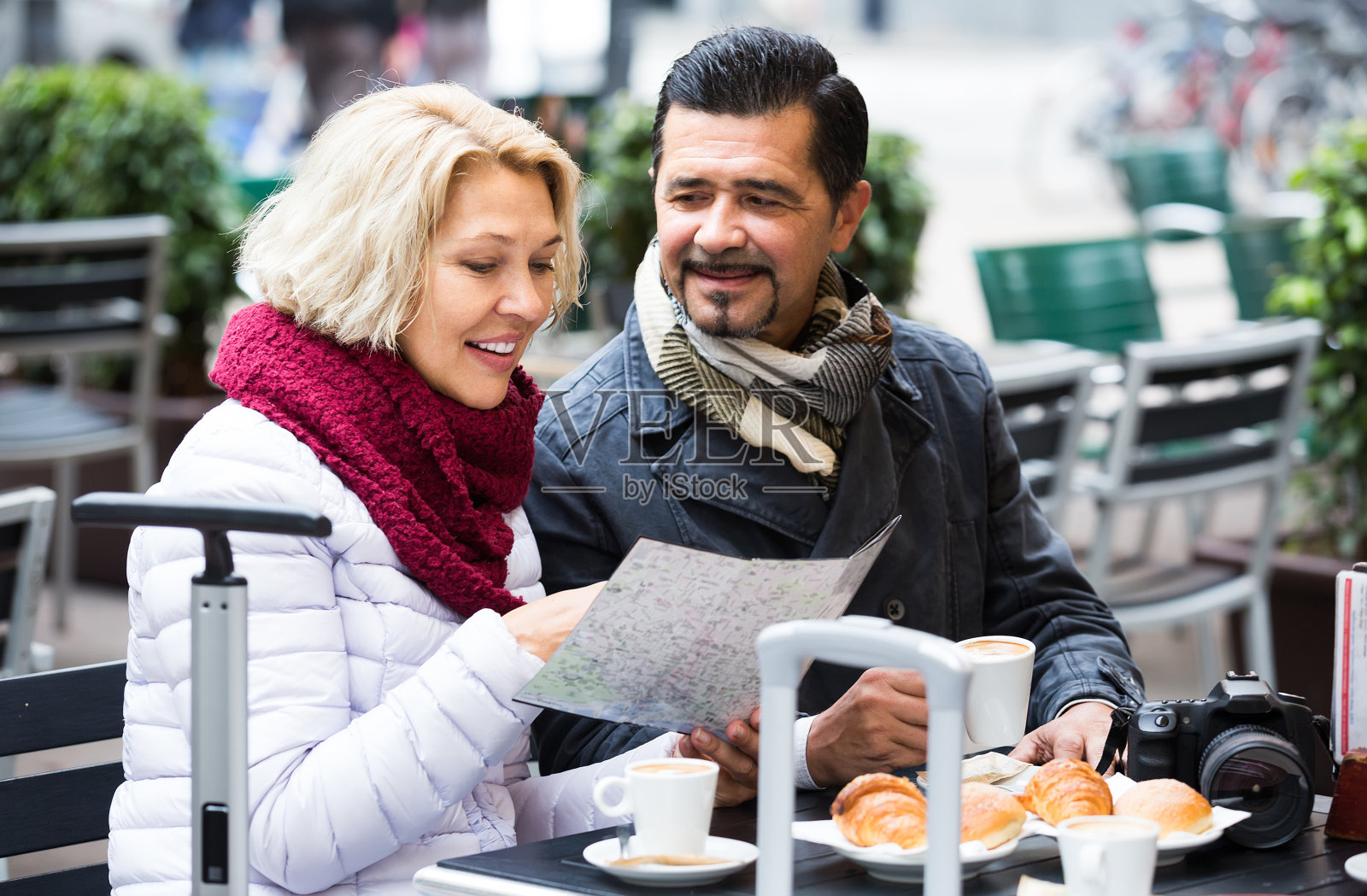 游客在咖啡馆喝咖啡，看地图照片摄影图片