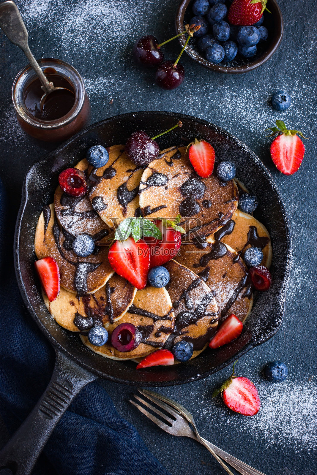 烤盘上有新鲜浆果和巧克力酱的煎饼照片摄影图片