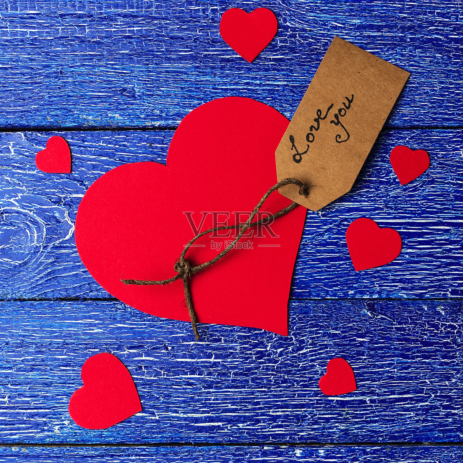 红色的心剪纸在蓝色的木头背景。照片摄影图片