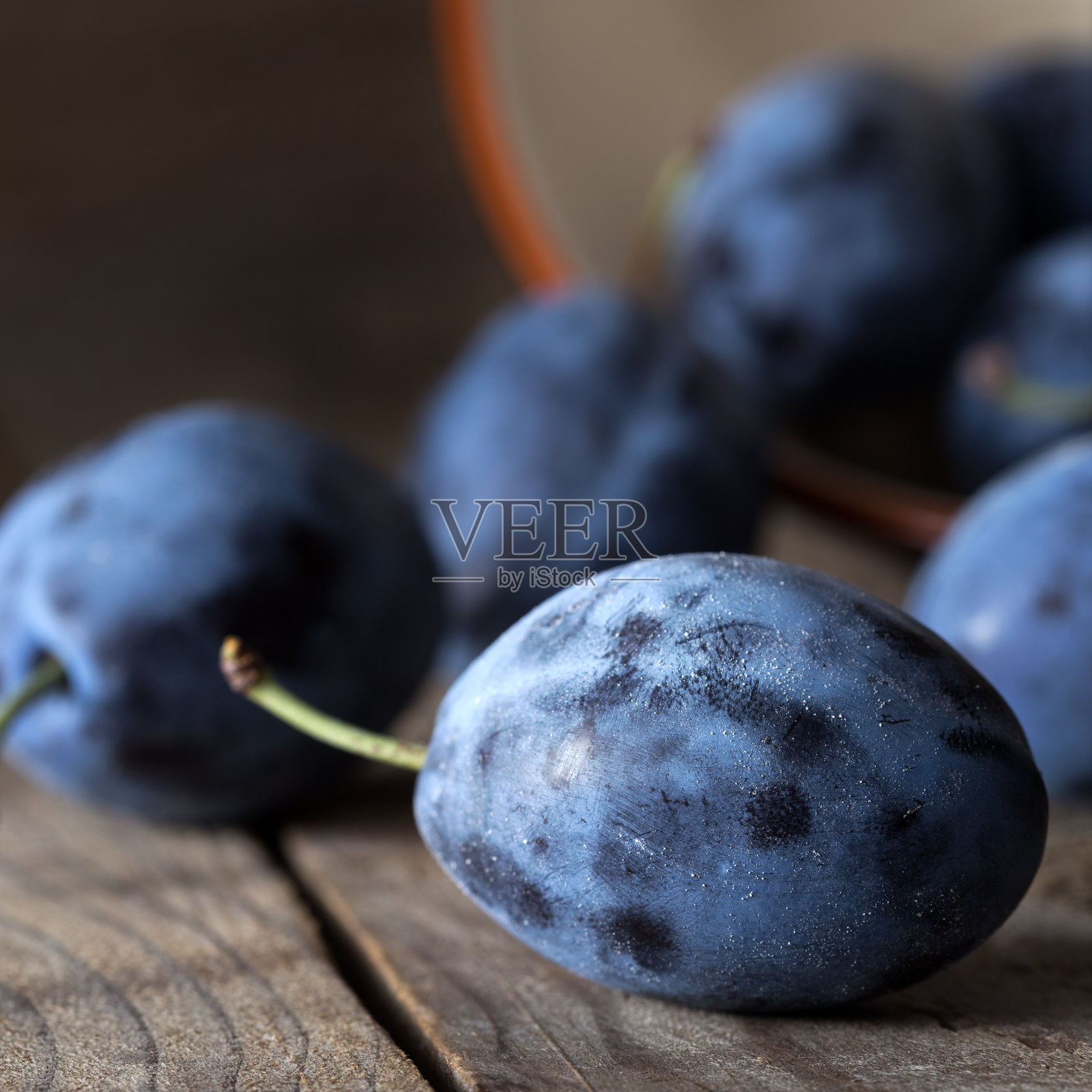 深色木桌背景上放着李子照片摄影图片