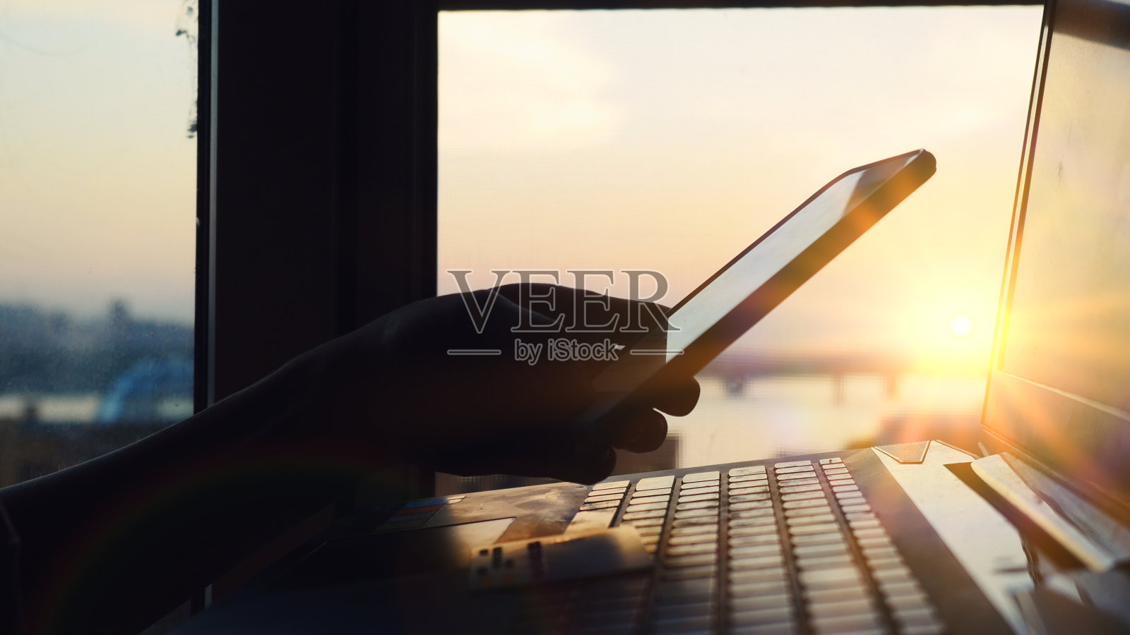 在线移动支付方法，使用手机智能手机和信用卡在惊人的日落和美丽的太阳光晕效果照片摄影图片